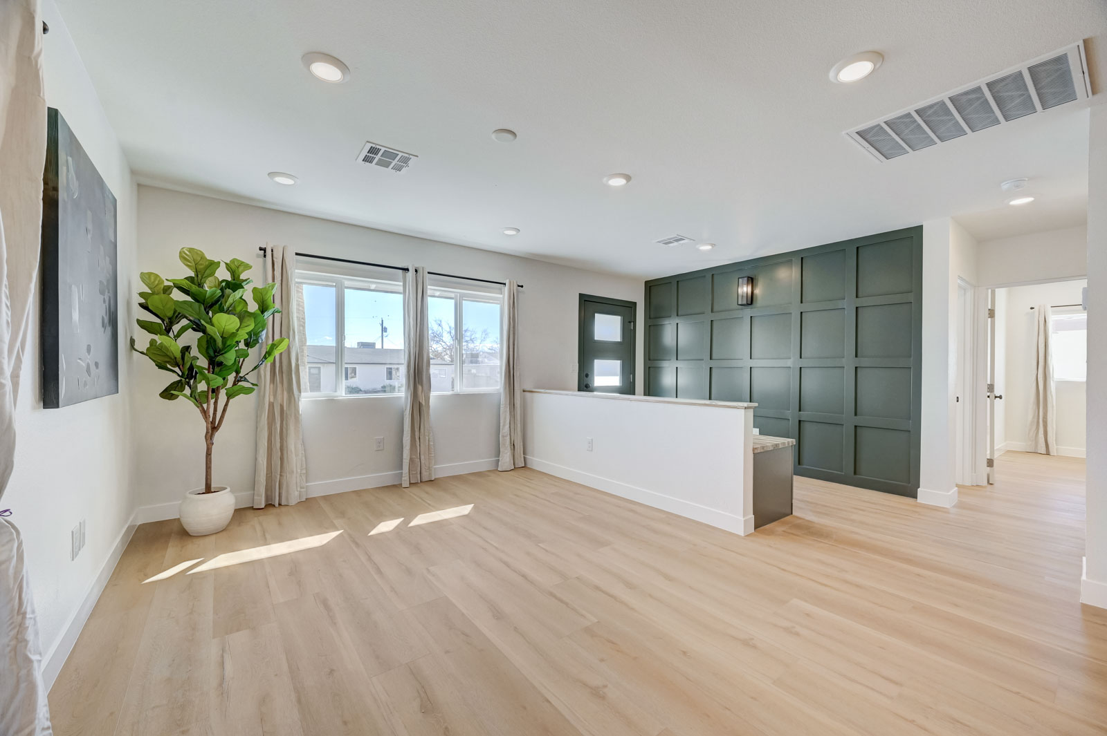 Open-concept living area with paneled accent wall